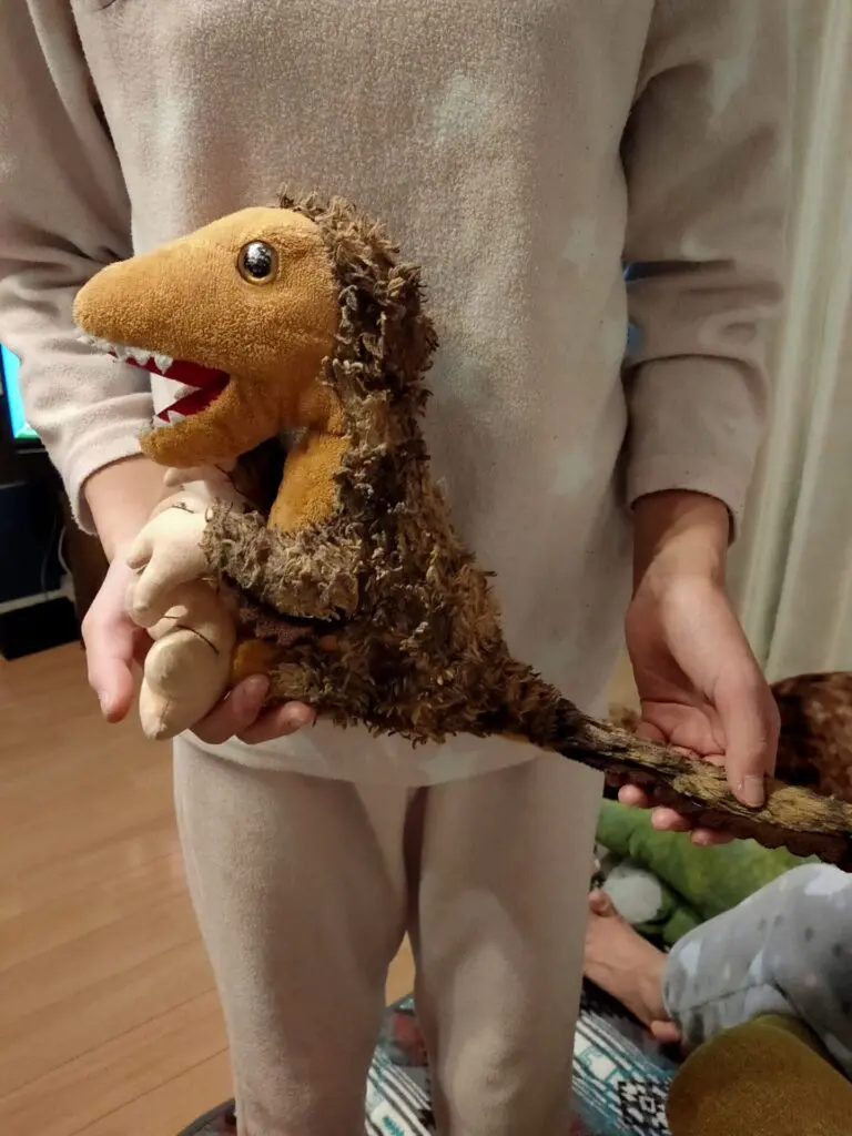 恐竜のぬいぐるみを抱いて寝る